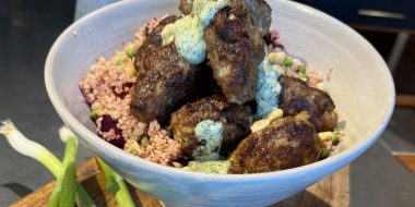 Gestoomde bulgur met geroosterde rode biet, feta, erwtjes en kruidige yoghurt met lamsköfte - recept